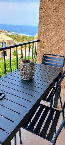 a blue picnic table with a basket on a balcony at Casa Mar, studio 4P, vue mer, Sant'Ambroggio, Lumio in Lumio