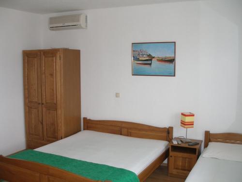a bedroom with two beds and a picture on the wall at Apartments Duce-Golubinka (239) in Duće
