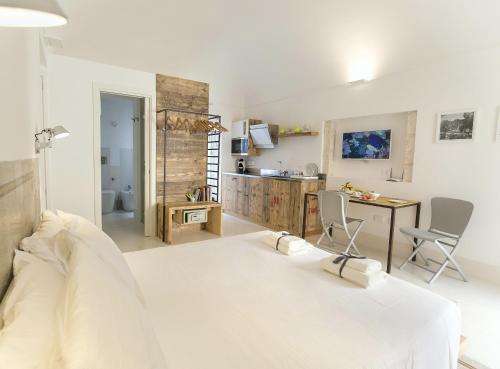 een slaapkamer met een bed, een bureau en een keuken bij Dione Apartments by Dimore in Sicily Ortigia in Siracusa