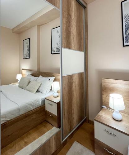une chambre avec un lit et un grand miroir dans l'établissement Borski Luxury Apartments, à Zlatibor