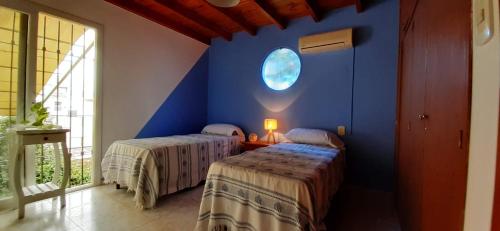 two beds in a room with a blue wall at 1780 Alojamiento in Guaymallen