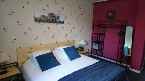 - une chambre avec un lit doté d'oreillers bleus et blancs dans l'établissement Chambres d'Hôtes Le Pont, à Égletons