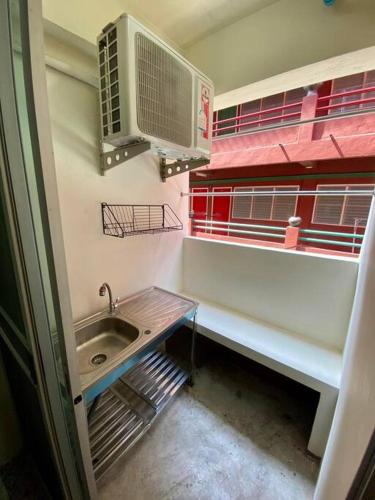a small bathroom with a sink and a window at Ratanawong Place 801 in Bangkok