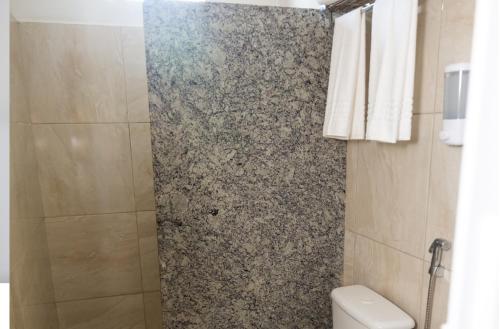 uma casa de banho com um chuveiro e um WC. em Pousada Freitas Alonso em Nova Viçosa