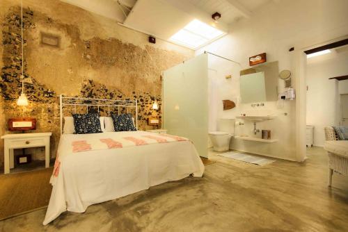a bedroom with a bed and a bathroom with a sink at La Casa de las Salinas in Punta de Mujeres