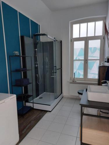 La salle de bains est pourvue d'une douche en verre et d'un lavabo. dans l'établissement Stadthaus mit Dachterrasse, à Varel