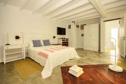 ein großes weißes Schlafzimmer mit einem Bett und einem Tisch in der Unterkunft La Casa de las Salinas in Punta de Mujeres