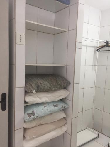 um armário com toalhas e uma almofada na casa de banho em Casa Enseada, Prainha, Praia Grande prox mar em São Francisco do Sul