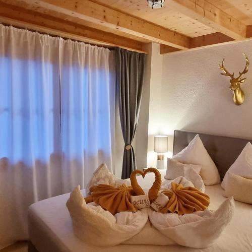 a bed with two towels on it with a window at Königin der Alpen in Beatenberg