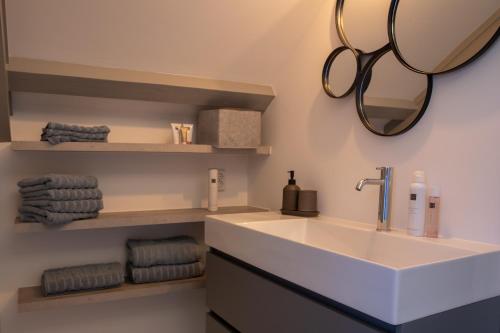a bathroom with a sink and a mirror and towels at Grand Monumental Residence Edam in Edam