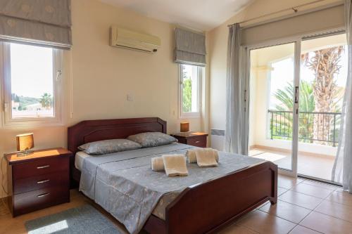 a bedroom with a bed with two towels on it at Villa Thalassa with private pool in Coral Bay