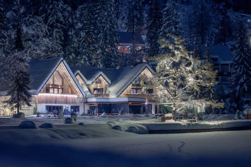 una casa grande con un árbol de Navidad delante de ella en Jasna Chalet Resort en Kranjska Gora