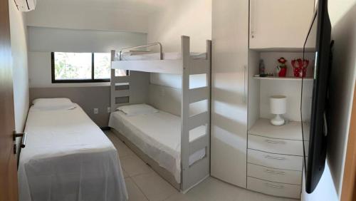 a bedroom with a bunk bed and a bed and a shelf at Cupe Beach Living Flat in Ipojuca