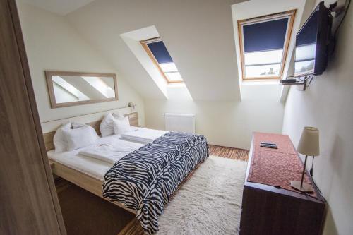 1 dormitorio con 1 cama, 1 mesa y 2 ventanas en Azúr Ház Gyöngyvirág Apartman en Sárvár