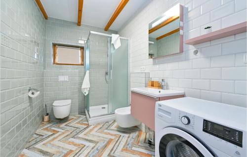 a bathroom with a washer and dryer in it at Cozy Home In Lonjica With Kitchen in Gračec