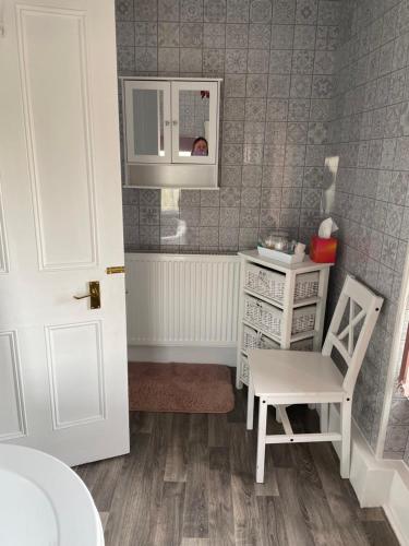 a small kitchen with a chair and a dresser at Dale View bed & breakfast in Holmrook