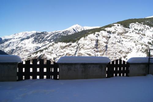 a fence in front of a snow covered mountain at Soldeu Paradis Soldeu in Soldeu