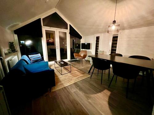 ein Wohnzimmer mit einem blauen Sofa und einem Tisch in der Unterkunft Holiday Home Maridu Forest in Arnhem