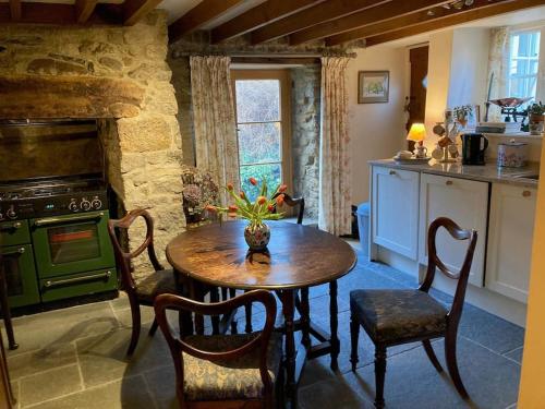 a kitchen with a table and a green stove at Little Reeds in Bovey Tracey