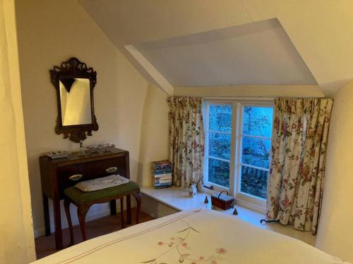 a bedroom with a bed and a window at Little Reeds in Bovey Tracey