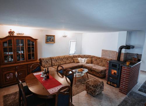 uma sala de estar com um sofá, uma mesa e um fogão em CosyHouse-Kupres em Kupres