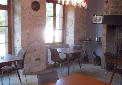 une salle à manger avec tables, chaises et fenêtres dans l'établissement Chambres d'Hôtes Le Pont, à Égletons