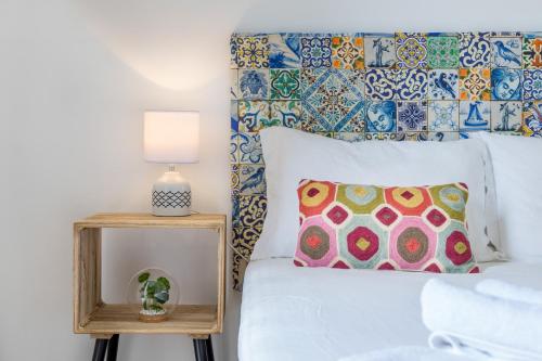 een slaapkamer met een wit bed en een bijzettafel bij The Color Hostel in Lissabon