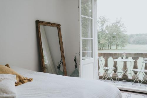 um quarto com uma cama, um espelho e uma mesa em Bleyckhof in een uniek natuurgebied em Ranst