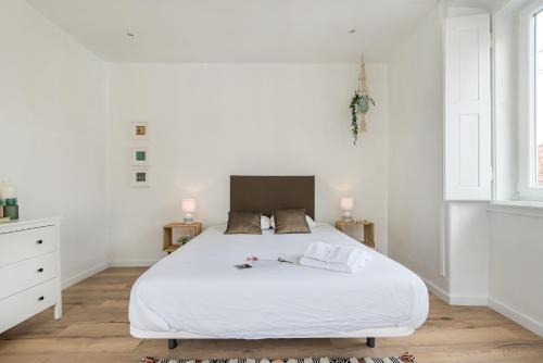 リスボンにあるThe Color Hostelの白いベッドルーム(白いベッド1台、窓付)