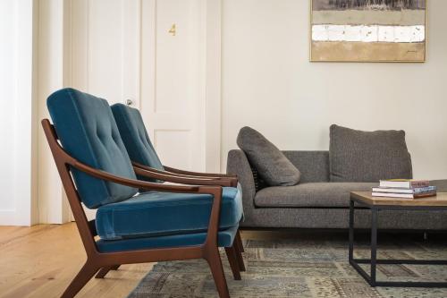 a living room with a blue chair and a couch at Santa Justa Prime Guesthouse in Lisbon