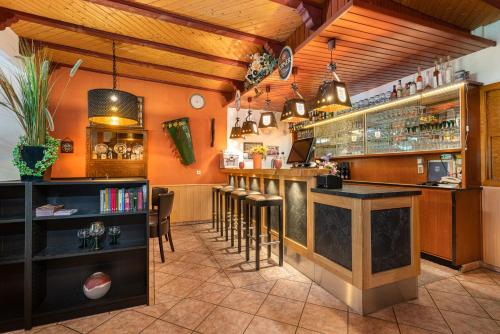 a restaurant with a bar with stools at Hotel Deis in Senheim