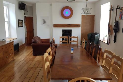 a dining room with a wooden table and a couch at Huge 7 bed hse for large groups close by the beach in Bude