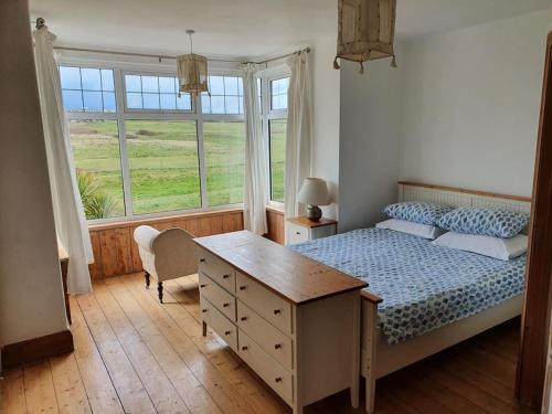 a bedroom with a bed and a desk and a window at Huge 7 bed hse for large groups close by the beach in Bude