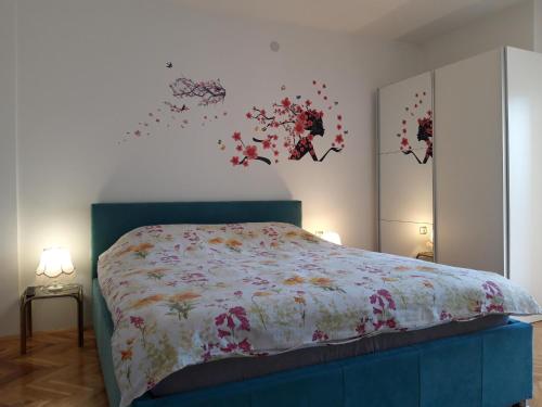 a bedroom with a bed with flowers on the wall at Apartment Goran and Milena in Ohrid