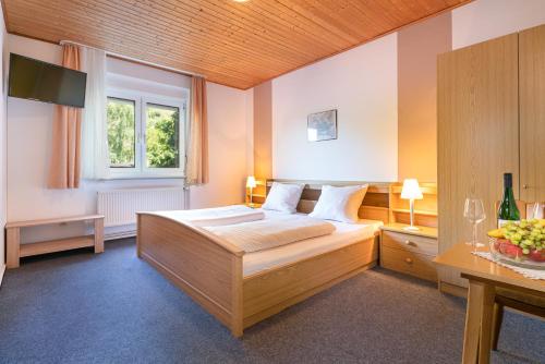 een slaapkamer met een bed, een raam en een televisie bij Hotel Deis in Senheim