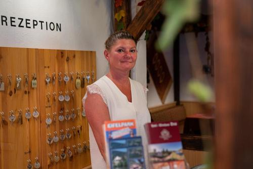 a woman is standing in front of a door at Hotel Deis in Senheim