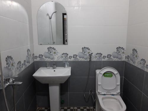 uma casa de banho com um lavatório, um WC e um espelho. em NHÀ NGHỈ T&T em Dồng Văn