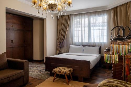 ein Schlafzimmer mit einem Bett, einem Sofa und einem Kronleuchter in der Unterkunft VESTA - Mokattam Residence in Kairo