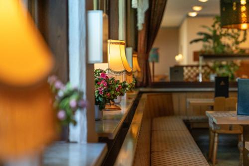 a restaurant with a table with flowers and a lamp at Hotel Deis in Senheim