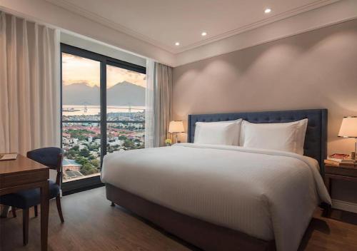 a bedroom with a large bed and a large window at Luxury Apartment in Sheraton Building with Ocean View in Da Nang