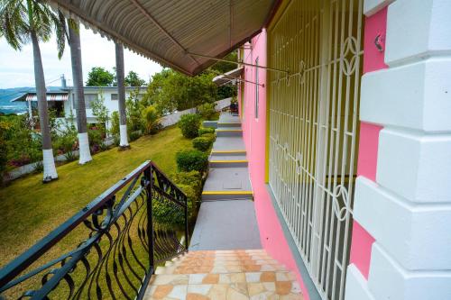 una casa rosa con escaleras que conducen a una casa en Three Palm Villa en Montego Bay