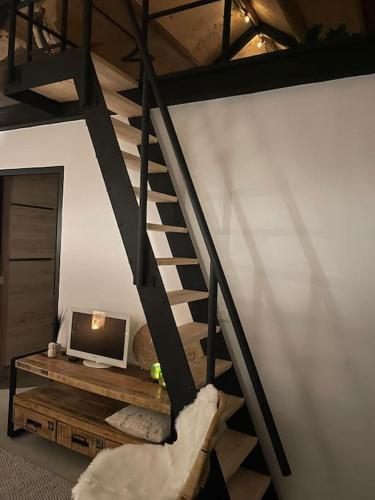 a living room with a staircase and a television at Tiny Seven in Otterlo