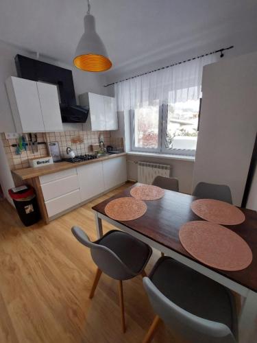 a kitchen with a table and chairs in a room at Kosciuszko Apartment in Muszyna