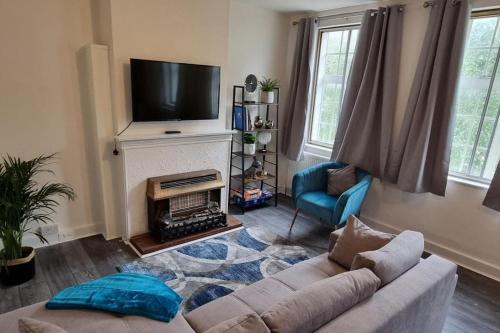 a living room with a couch and a television at Urban Oasis l 3-Bed Gem in Watford Town Center in Watford