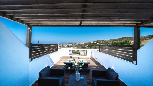 a balcony with a table and chairs on it at Panorama Village Hotel in Agia Pelagia