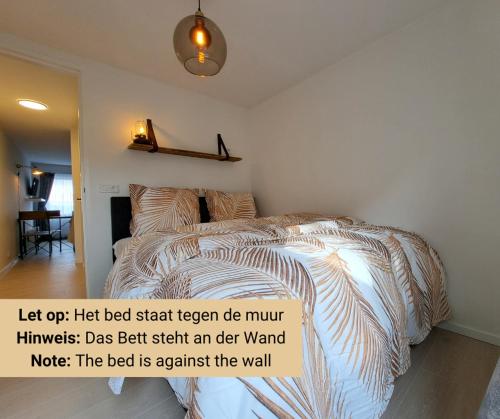 a bed in a bedroom with a poster on the wall at Zandkasteel Domburg in Domburg