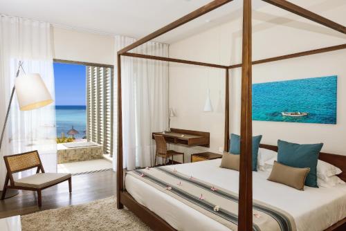 ein Schlafzimmer mit einem Bett und ein Zimmer mit Meerblick in der Unterkunft Esplanade by Horizon Holidays in Tamarin