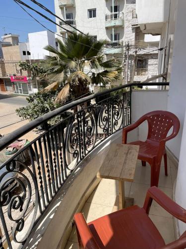 a balcony with a table and chairs and a palm tree at One love in Dakar