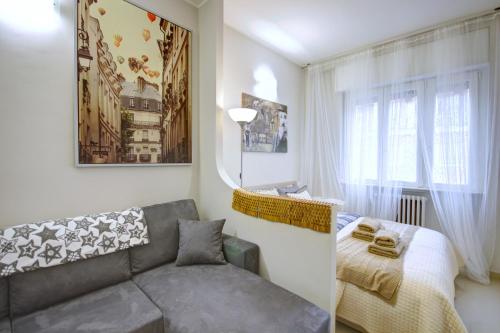 een woonkamer met een bank en een bed bij MilanRentals - Charlie Apartment in Milaan
