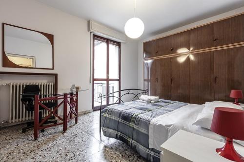 una camera con letto, scrivania e specchio di MilanRentals - Vigliani Apartments a Milano